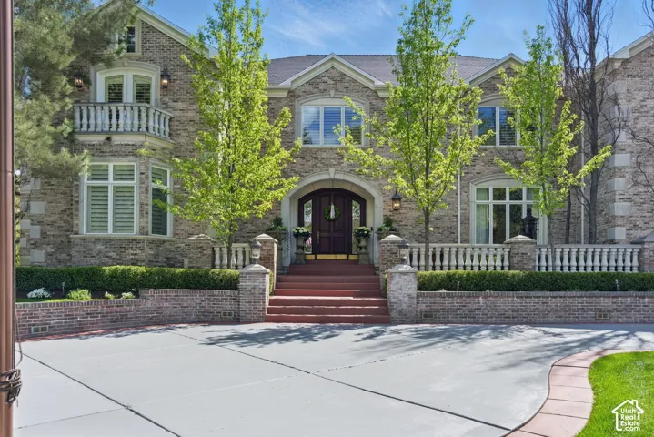 View of front of property featuring brick siding and a balcony