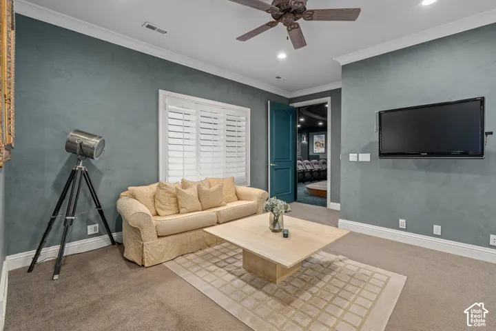 Living room with ornamental molding, recessed lighting, carpet flooring, and ceiling fan