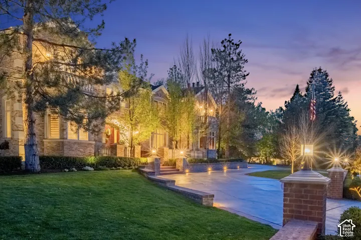 Pool at dusk featuring a lawn and a patio