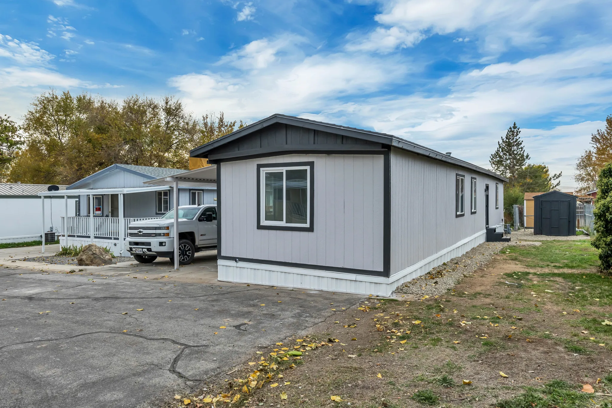 View of property exterior featuring a storage unit and driveway