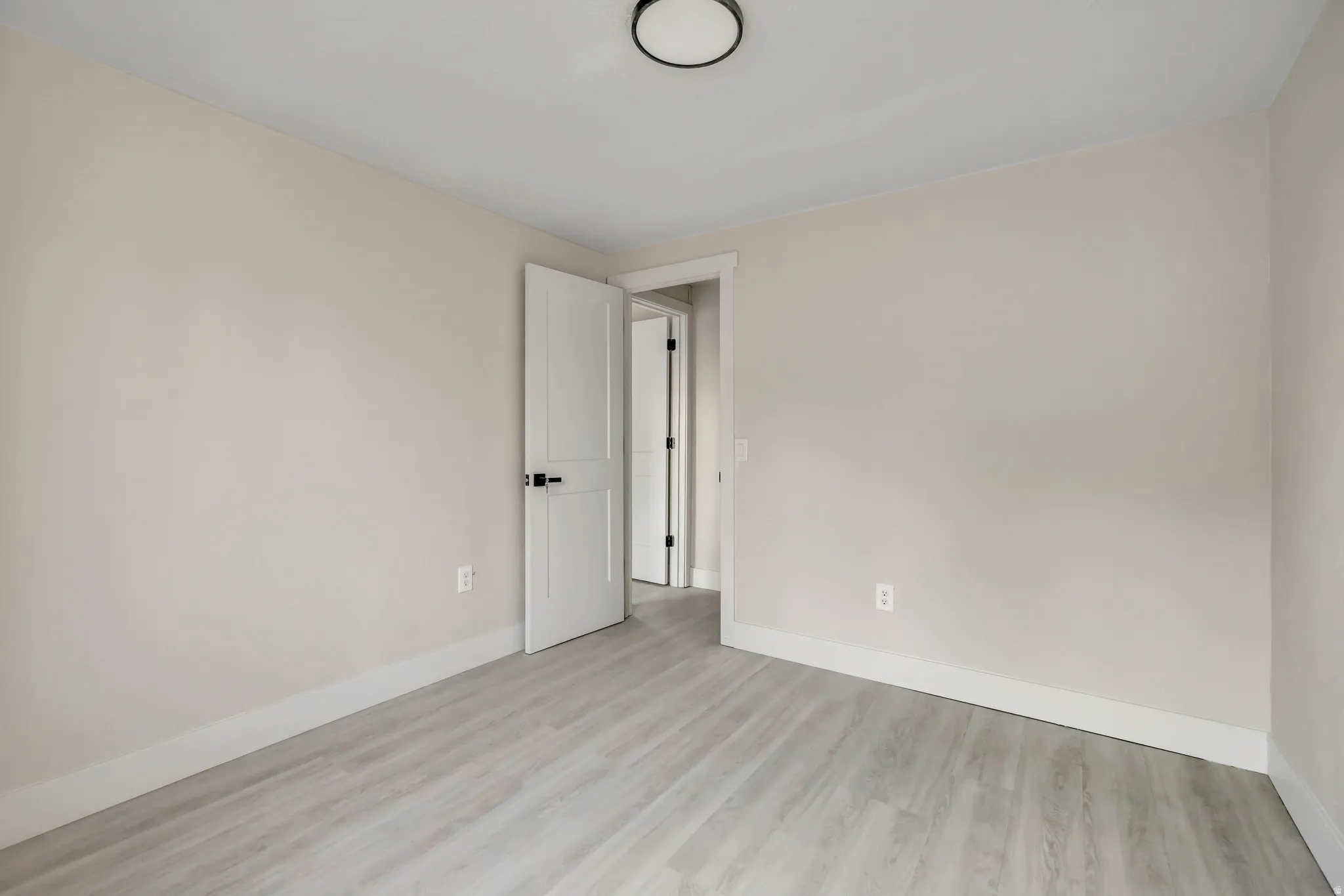 Empty room with baseboards and light wood-style floors