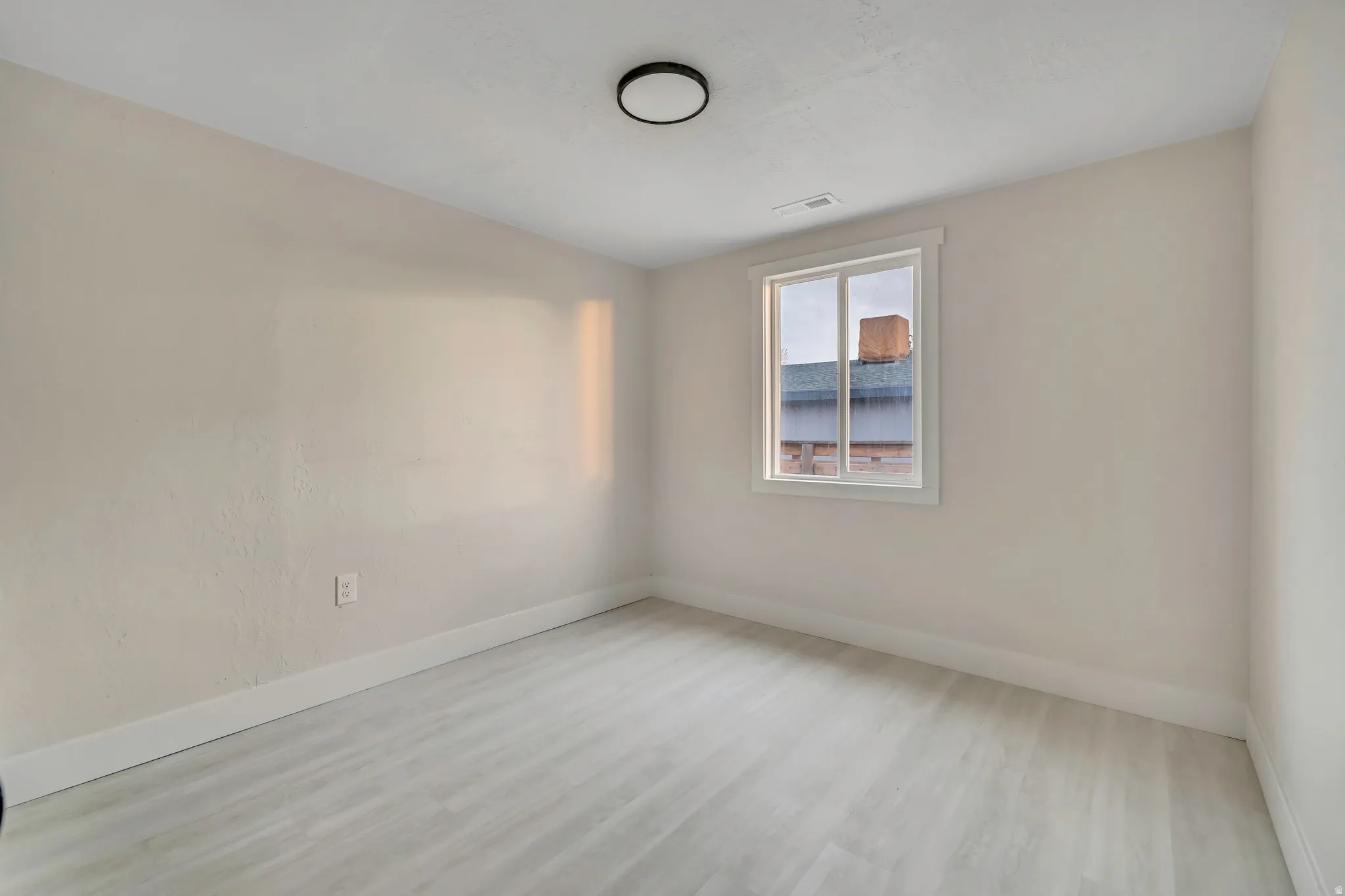 Spare room with light wood-style floors and baseboards