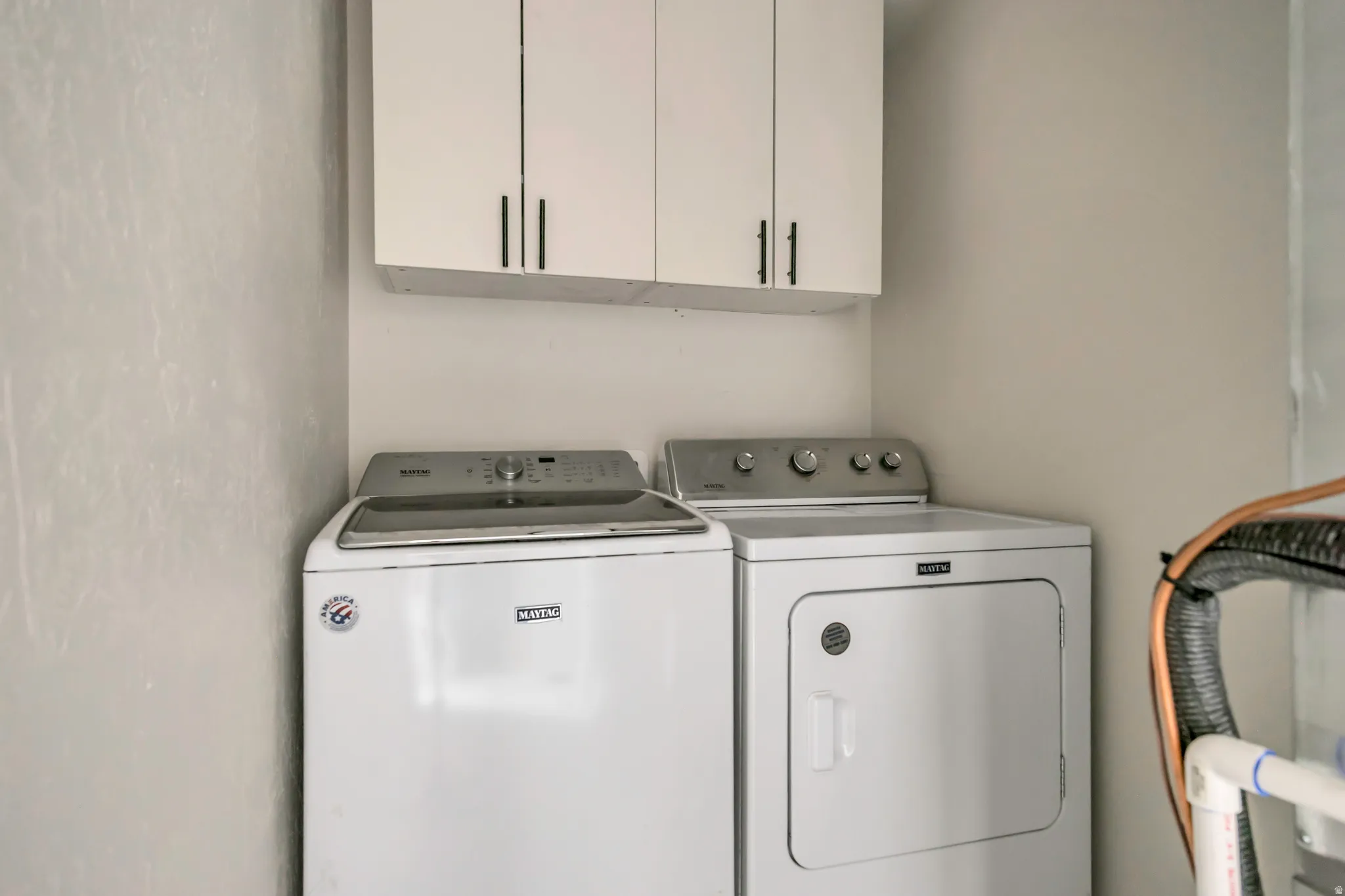 Laundry area featuring cabinet space and washer and clothes dryer