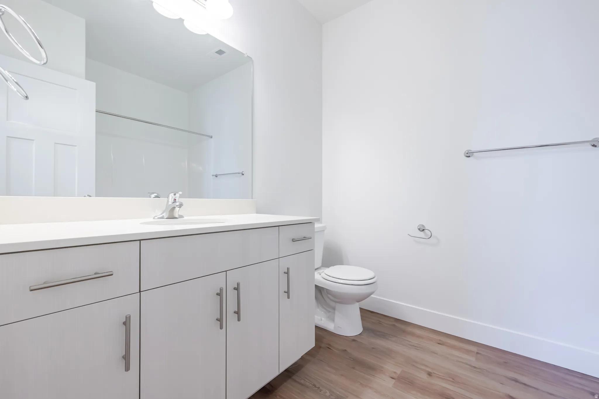 Bathroom with vanity, light wood finished floors, and a shower