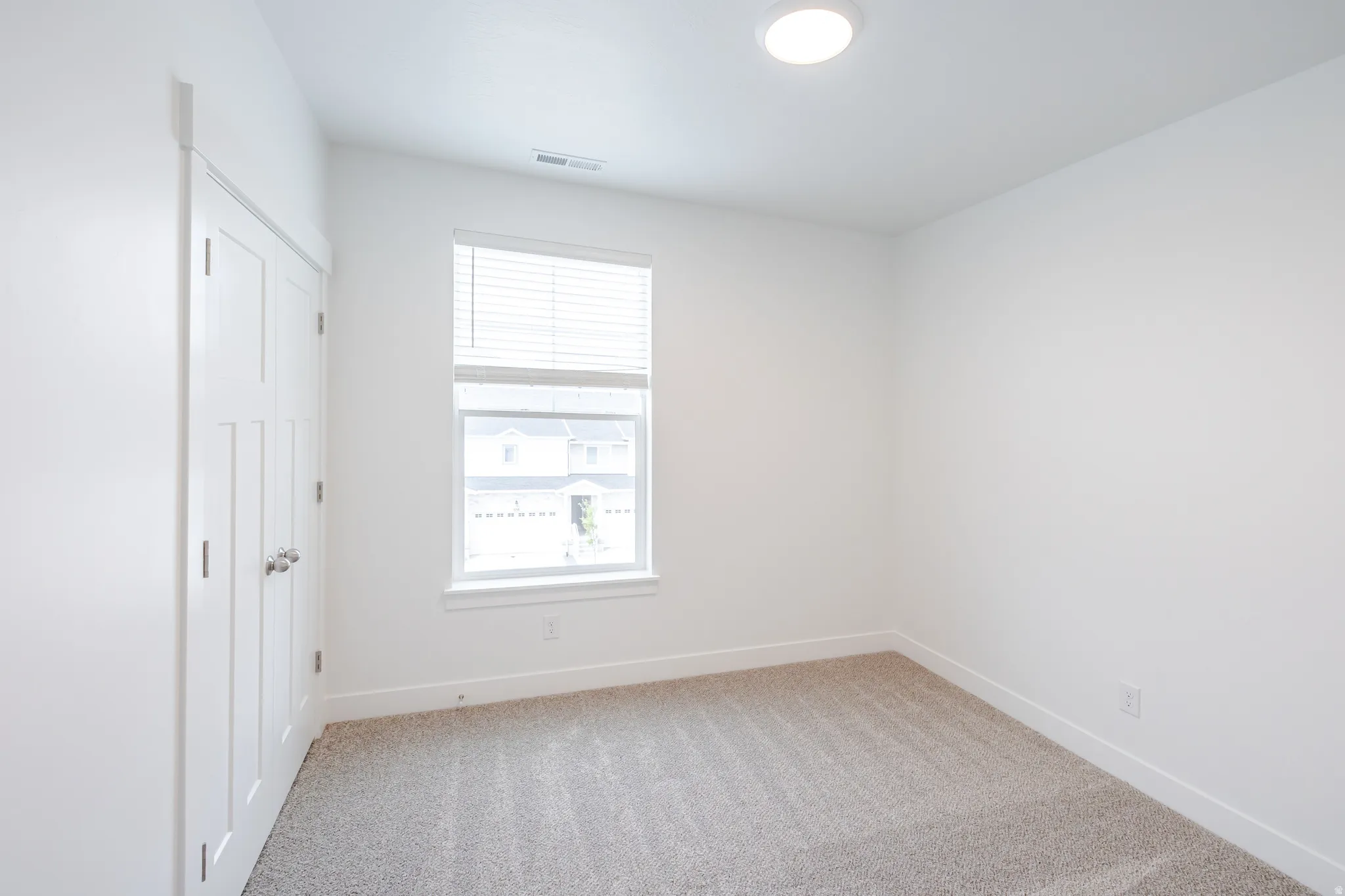 Unfurnished bedroom with light colored carpet and a closet
