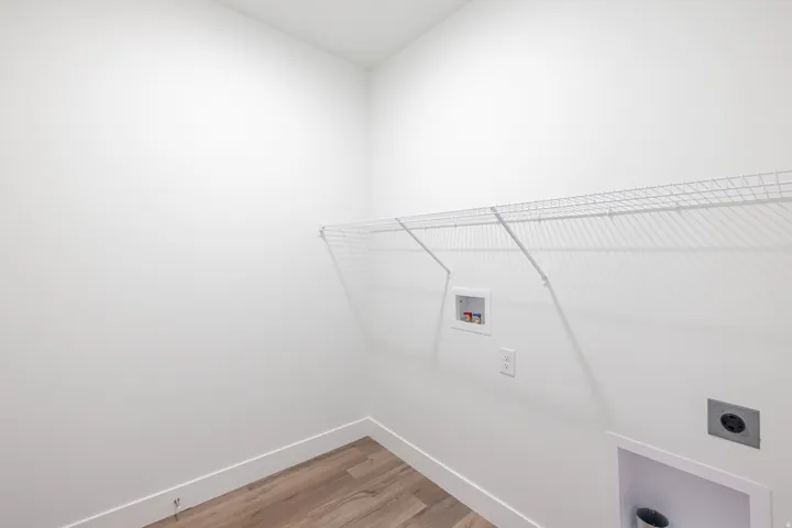 Laundry room with light wood finished floors, hookup for a washing machine, and hookup for an electric dryer