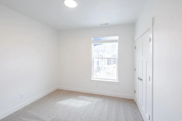 Spare room featuring light carpet and baseboards