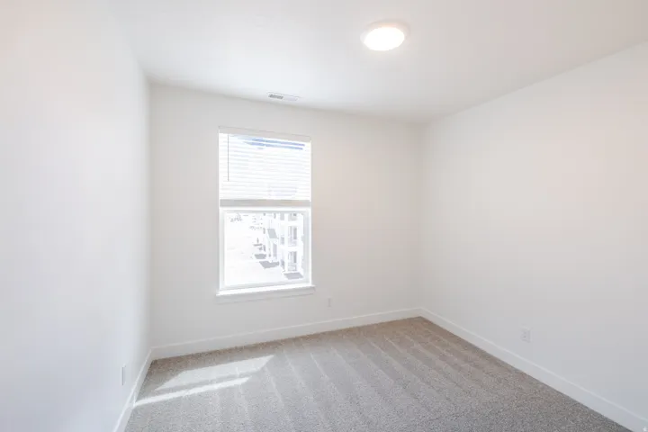 Spare room featuring light colored carpet and baseboards