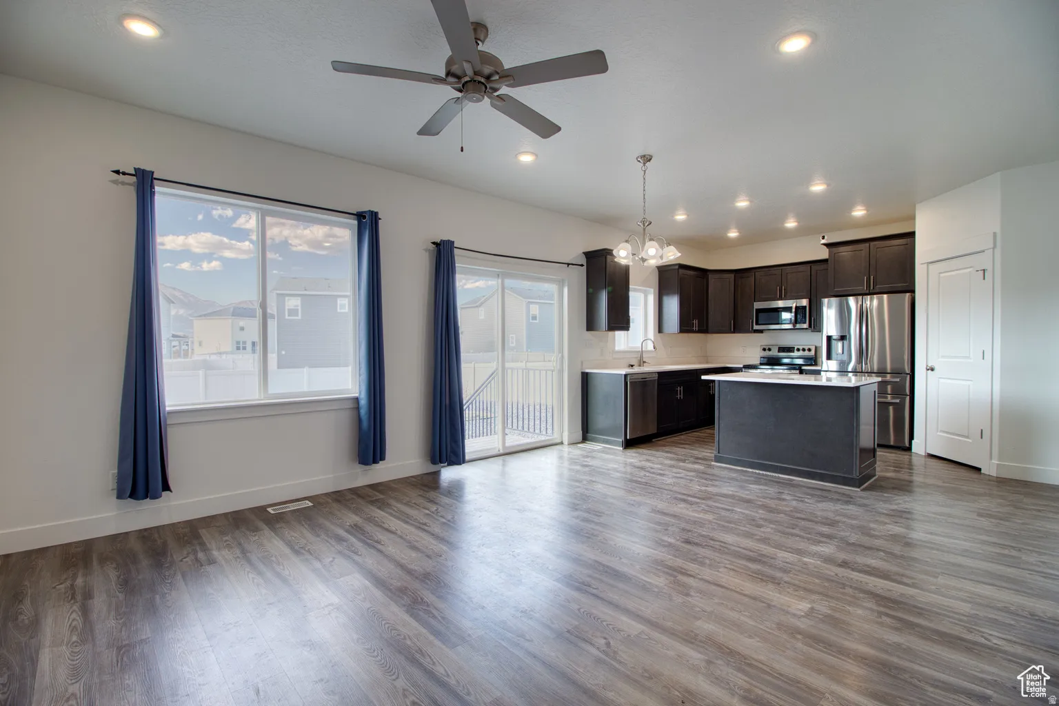 Kitchen featuring a chandelier, recessed lighting, dark brown cabinetry, stainless steel appliances, and a center island