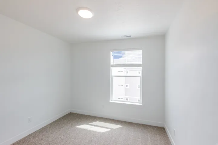 Spare room featuring baseboards and light carpet