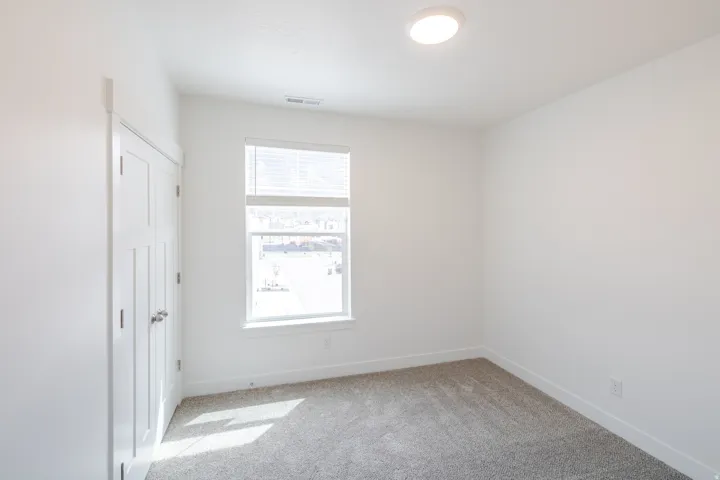 Unfurnished bedroom featuring baseboards and light colored carpet