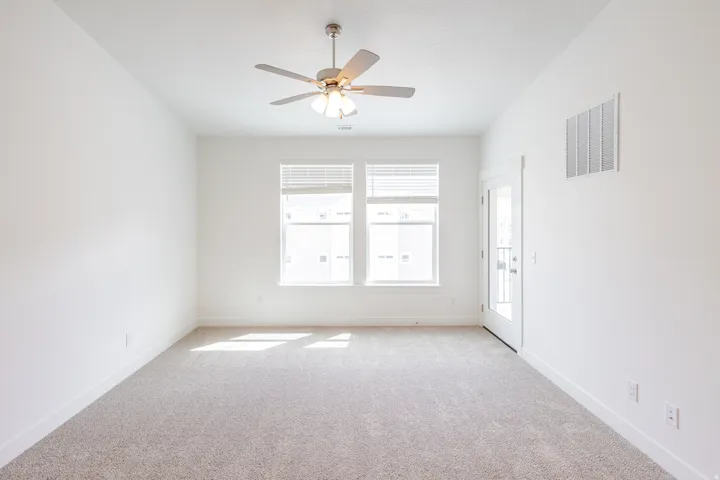 Spare room with light carpet and ceiling fan
