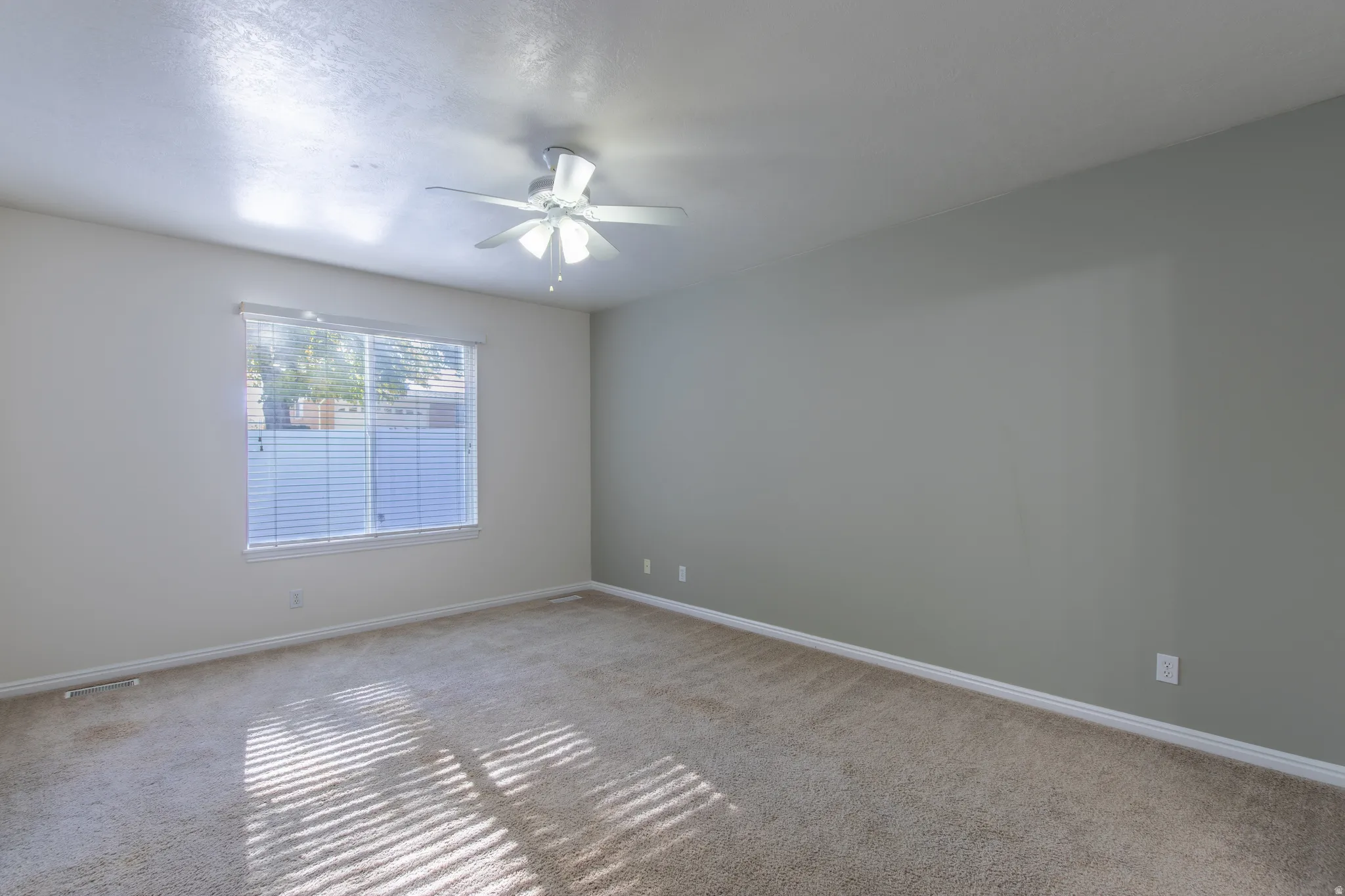 Unfurnished room with carpet floors and a ceiling fan