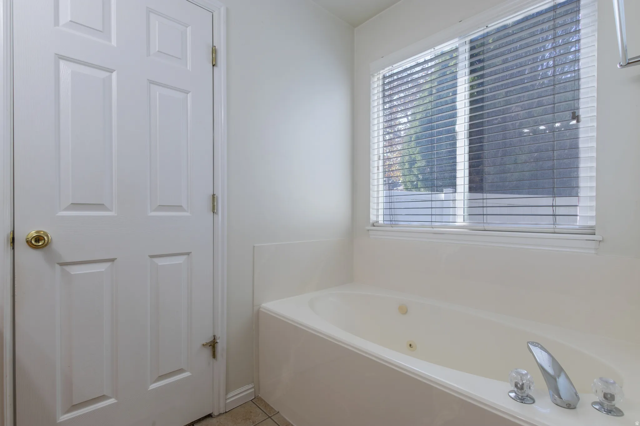 Bathroom with a whirlpool tub and light tile patterned floors