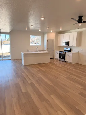 Kitchen with white cabinets, light countertops, a textured ceiling, stainless steel appliances, and ceiling fan