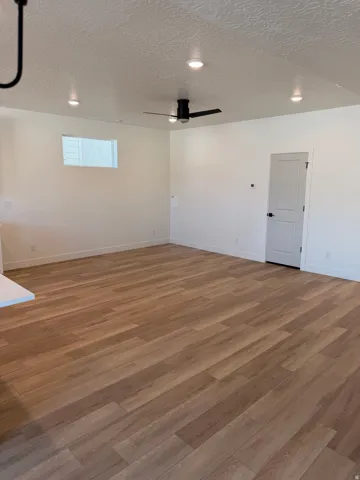 Spare room with a textured ceiling, wood finished floors, ceiling fan, and recessed lighting