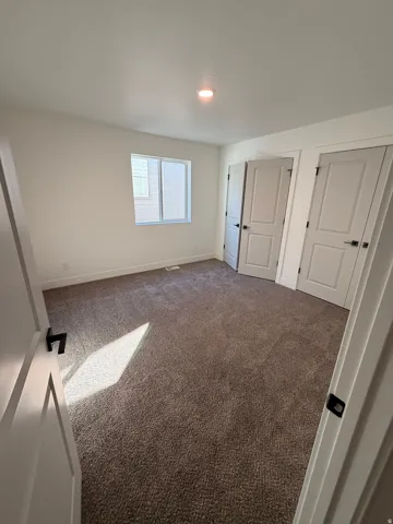 Unfurnished bedroom featuring baseboards and carpet flooring