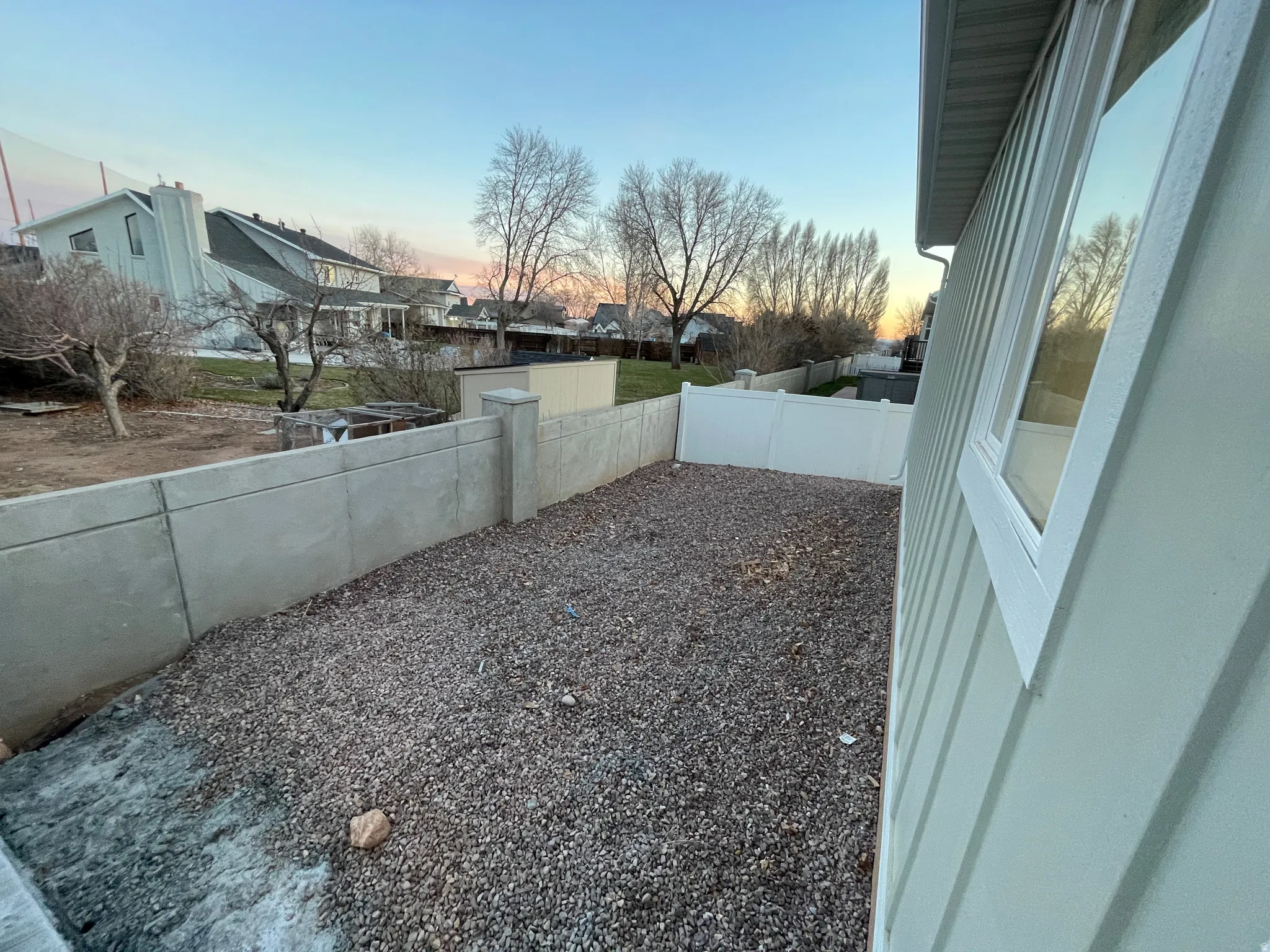 Yard at dusk featuring a fenced backyard and a residential view