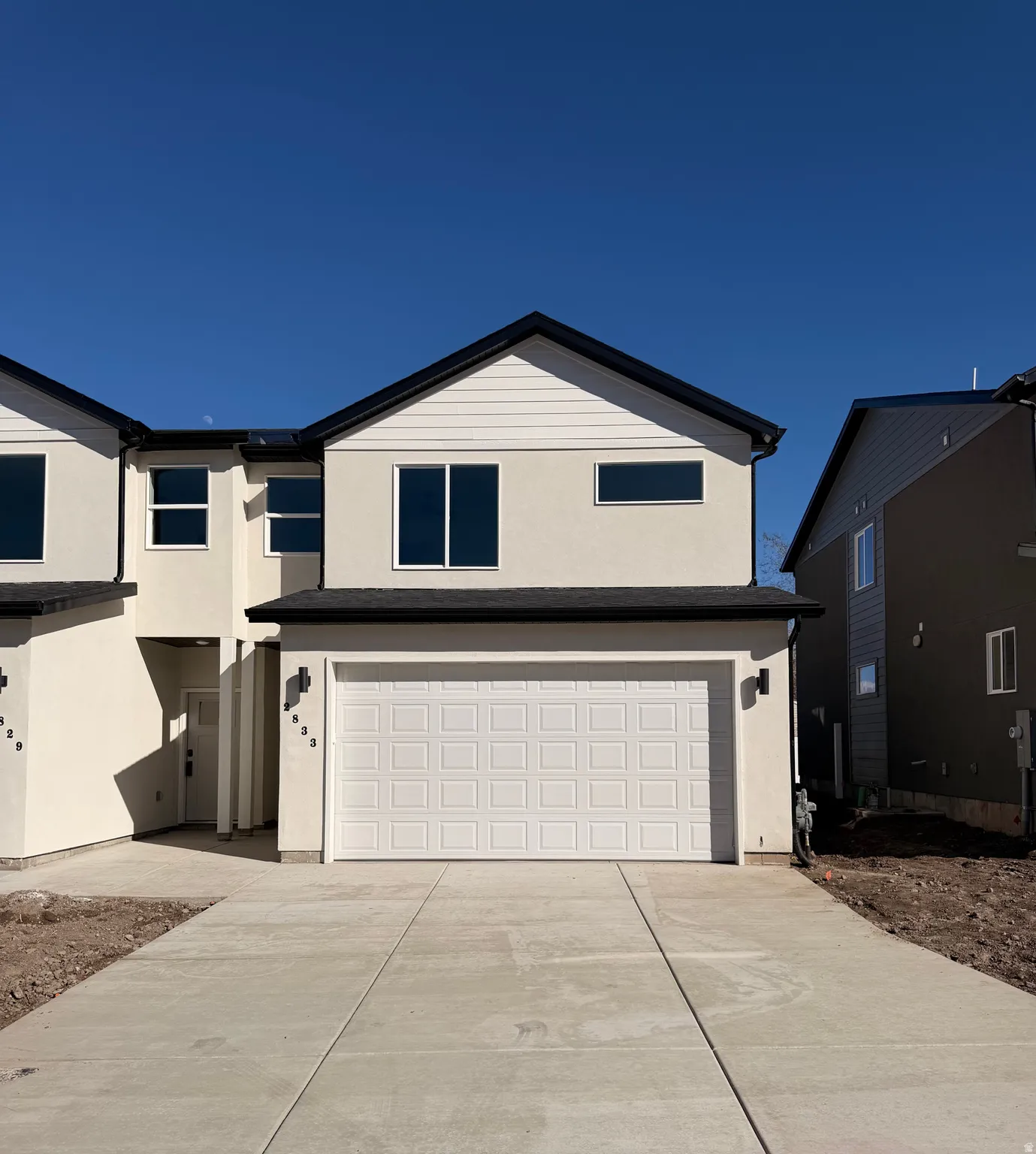 View of front of house featuring stucco siding, a garage, and driveway