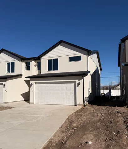 View of front of property with an attached garage, stucco siding, and concrete driveway