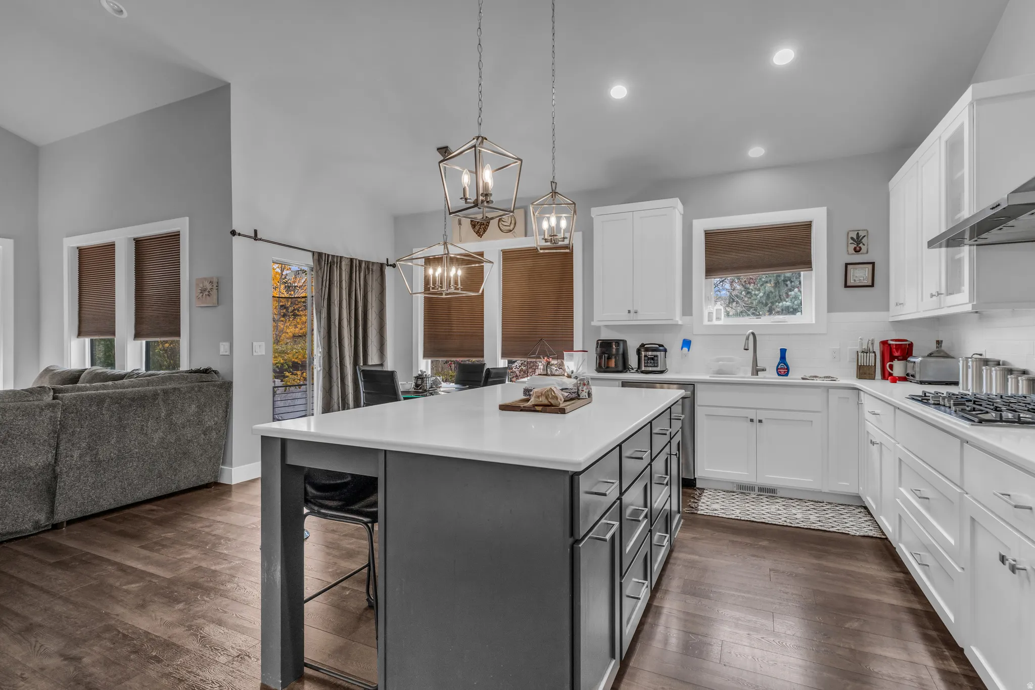 Kitchen with white cabinetry, open floor plan, a kitchen breakfast bar, dark wood-style floors, and recessed lighting
