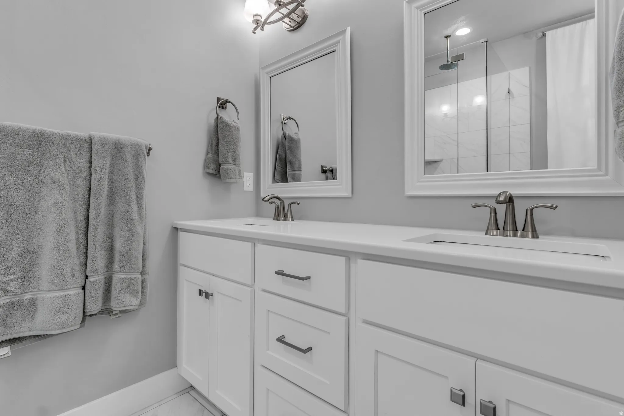 Full bath with double vanity and a shower