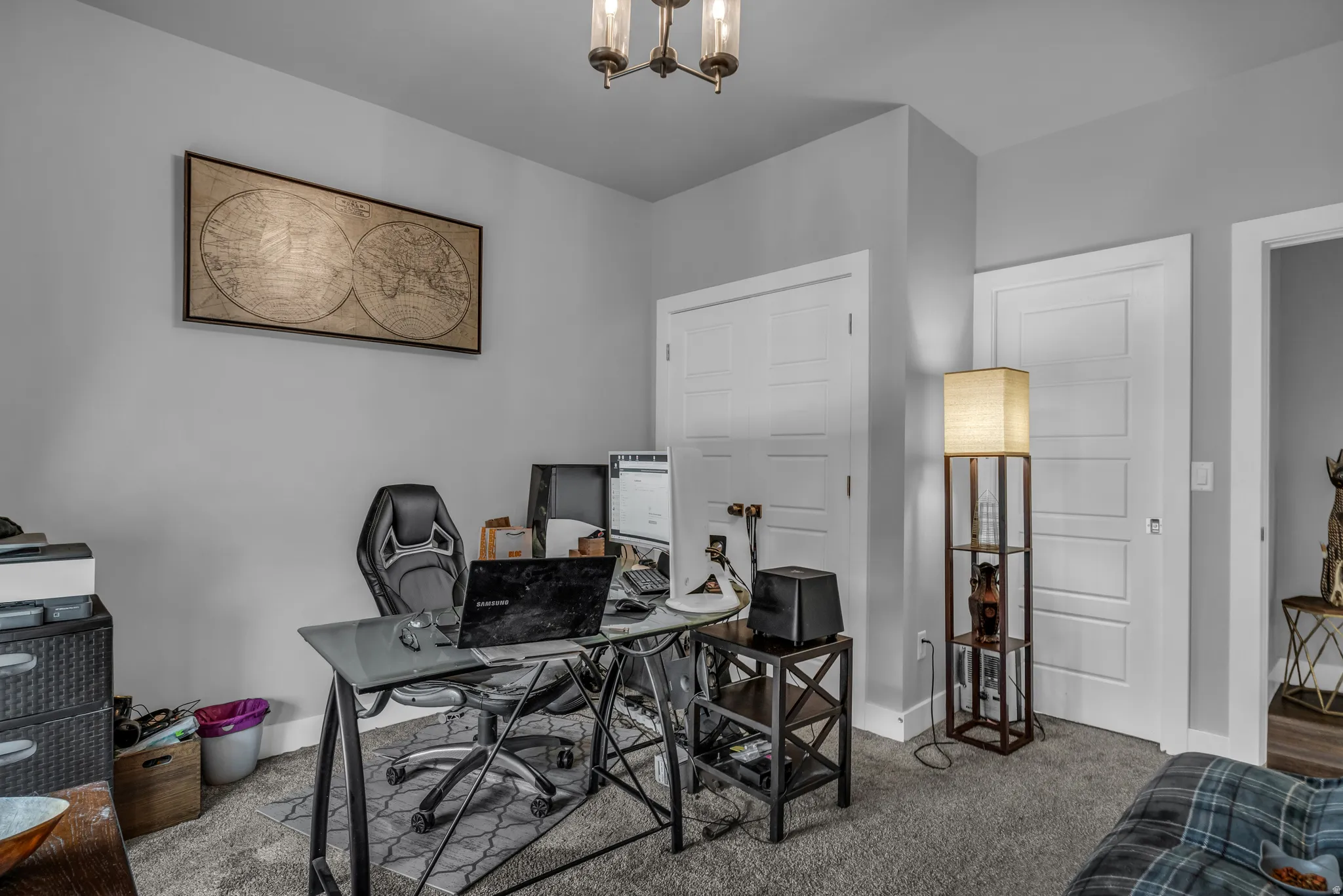Office with carpet floors and a chandelier