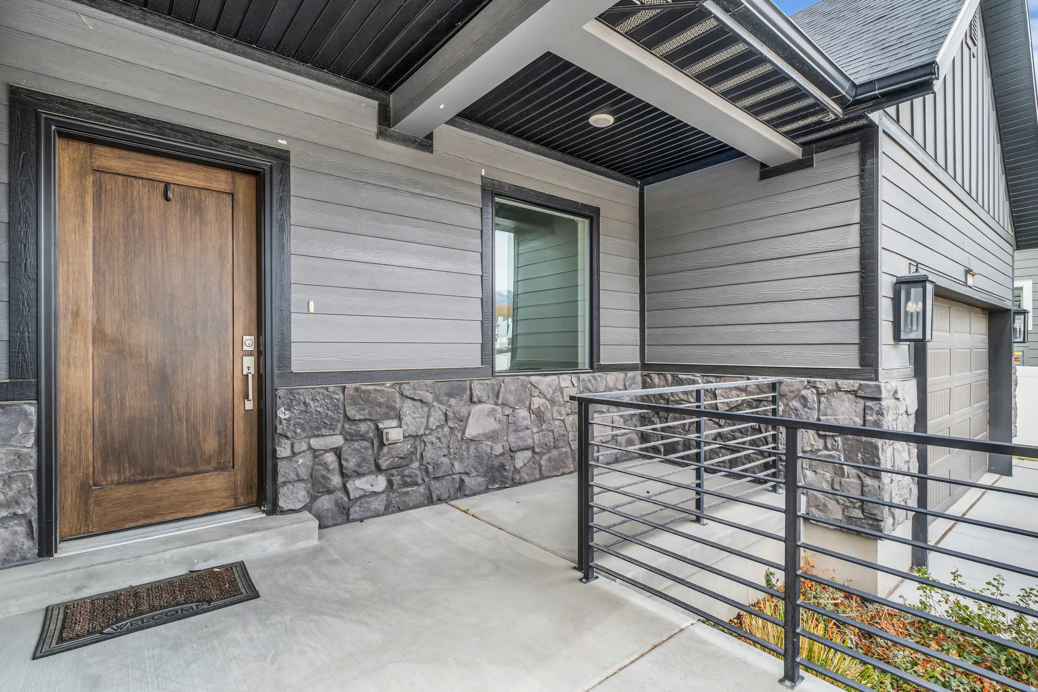 View of exterior entry with stone siding and an attached garage