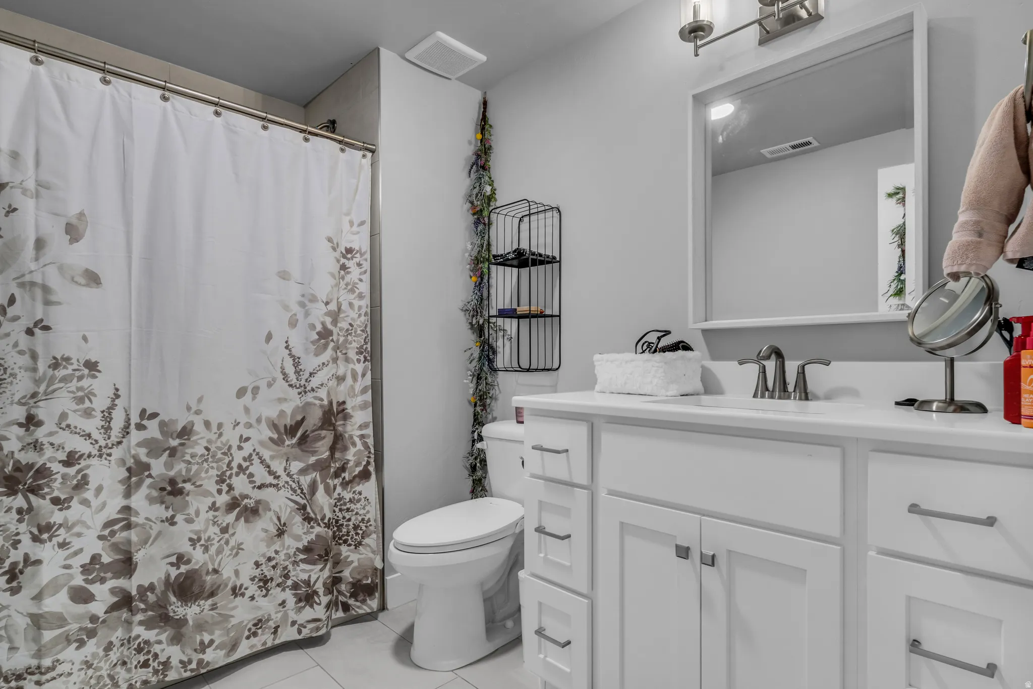 Bathroom featuring light tile patterned flooring, vanity, and a shower with curtain