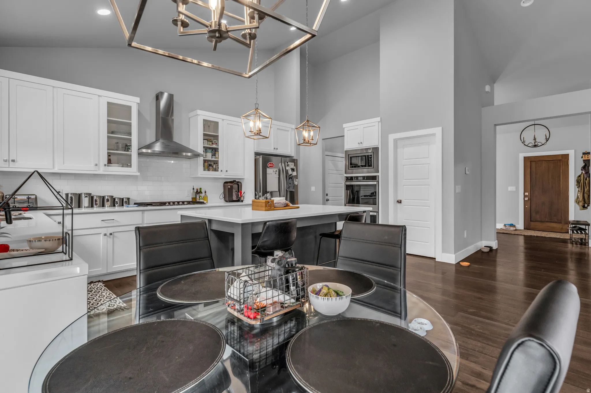 Kitchen featuring backsplash, a kitchen island, dark wood-type flooring, glass insert cabinets, and white cabinetry