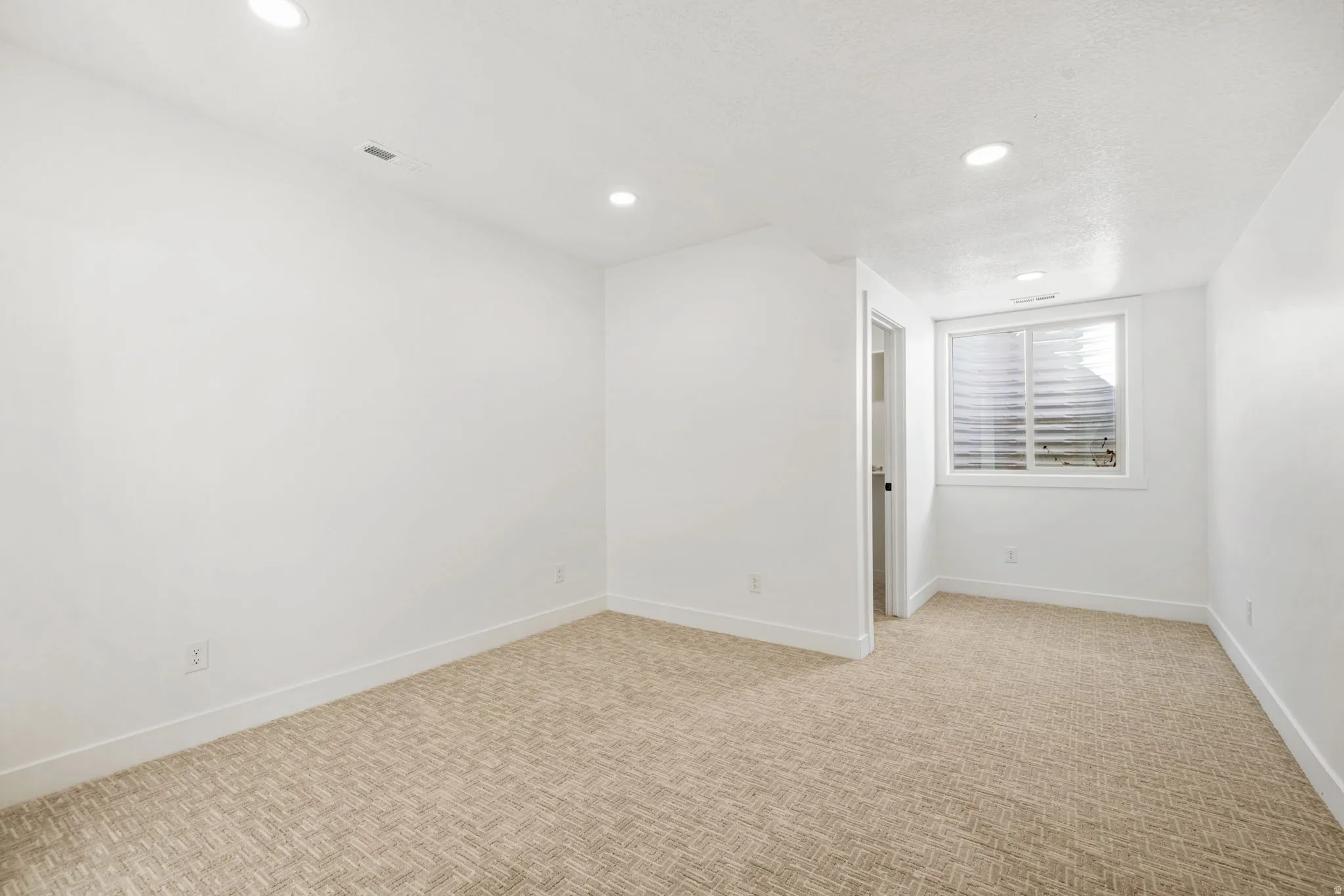 Spare room with recessed lighting and light colored carpet
