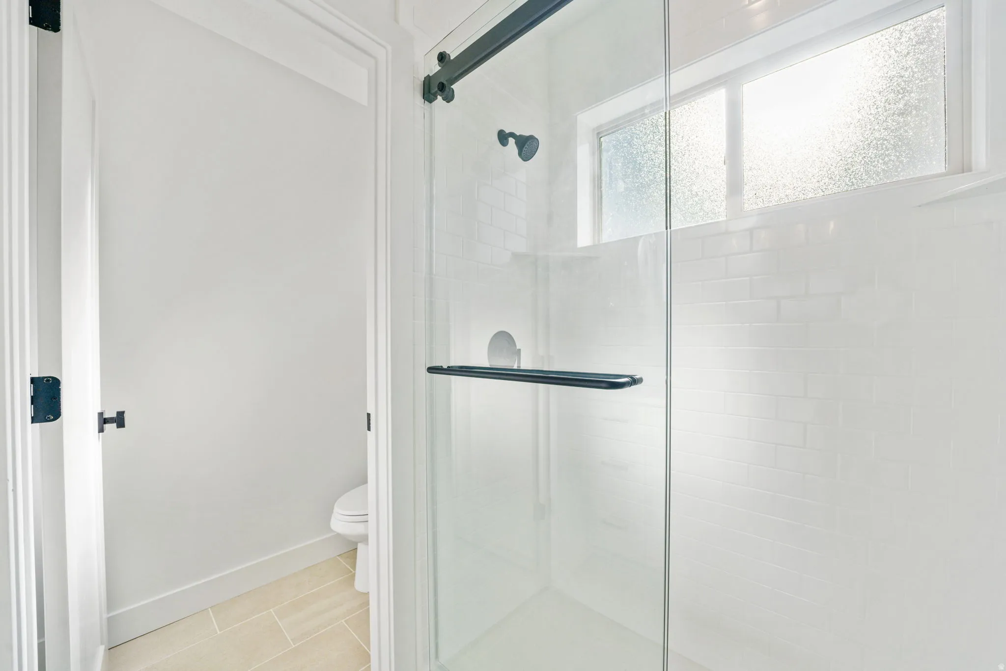 Bathroom with a shower stall and tile patterned flooring