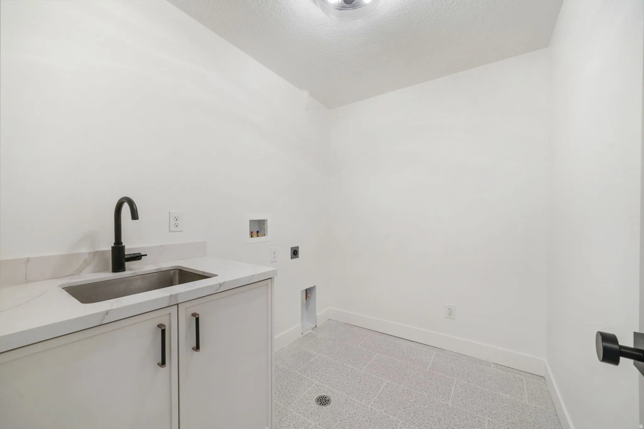 Laundry area featuring washer hookup, a textured ceiling, cabinet space, and electric dryer hookup