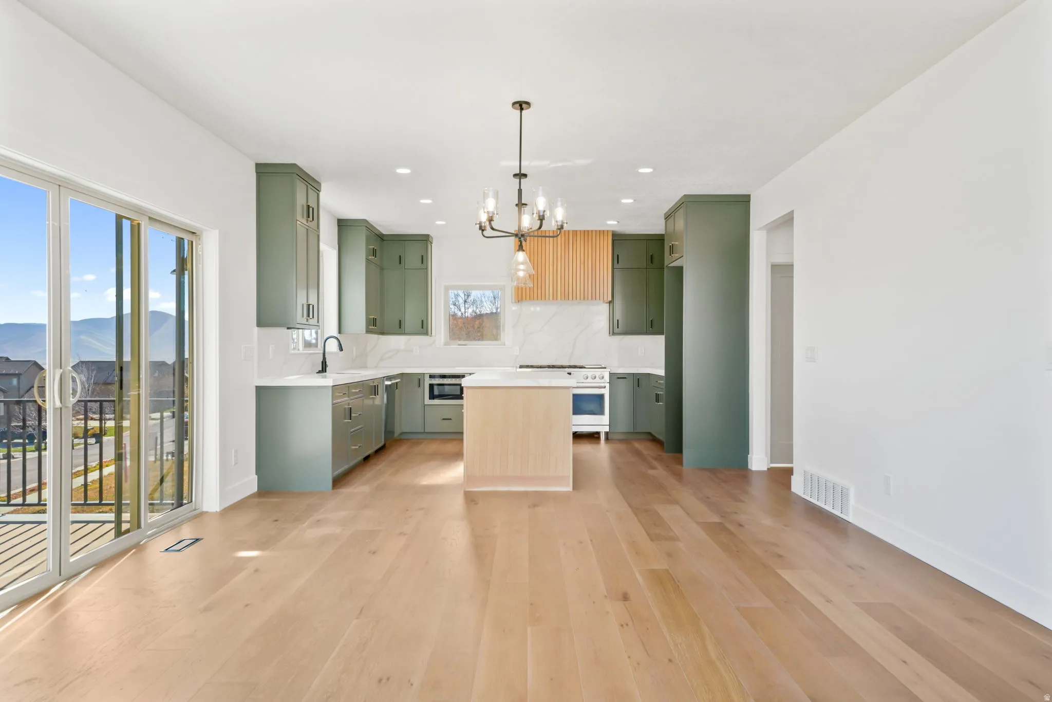 Kitchen featuring green cabinets, light countertops, tasteful backsplash, and recessed lighting