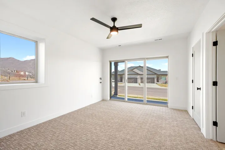 Empty room featuring carpet, ceiling fan, and a textured ceiling