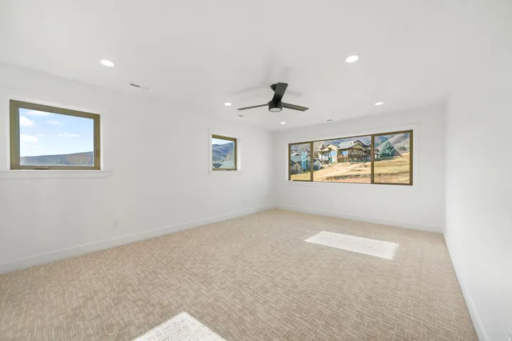 Carpeted empty room with recessed lighting and a ceiling fan