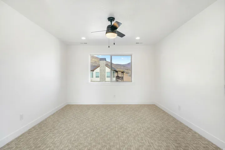 Spare room featuring ceiling fan, light carpet, and recessed lighting