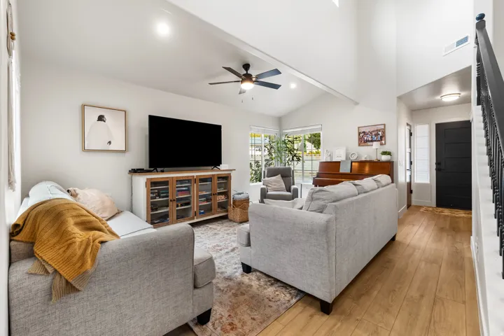 Living area with wood finished floors, a ceiling fan, high vaulted ceiling, beamed ceiling, and recessed lighting
