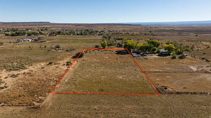 Aerial view of sparsely populated area with property parcel outlined and a desert landscape