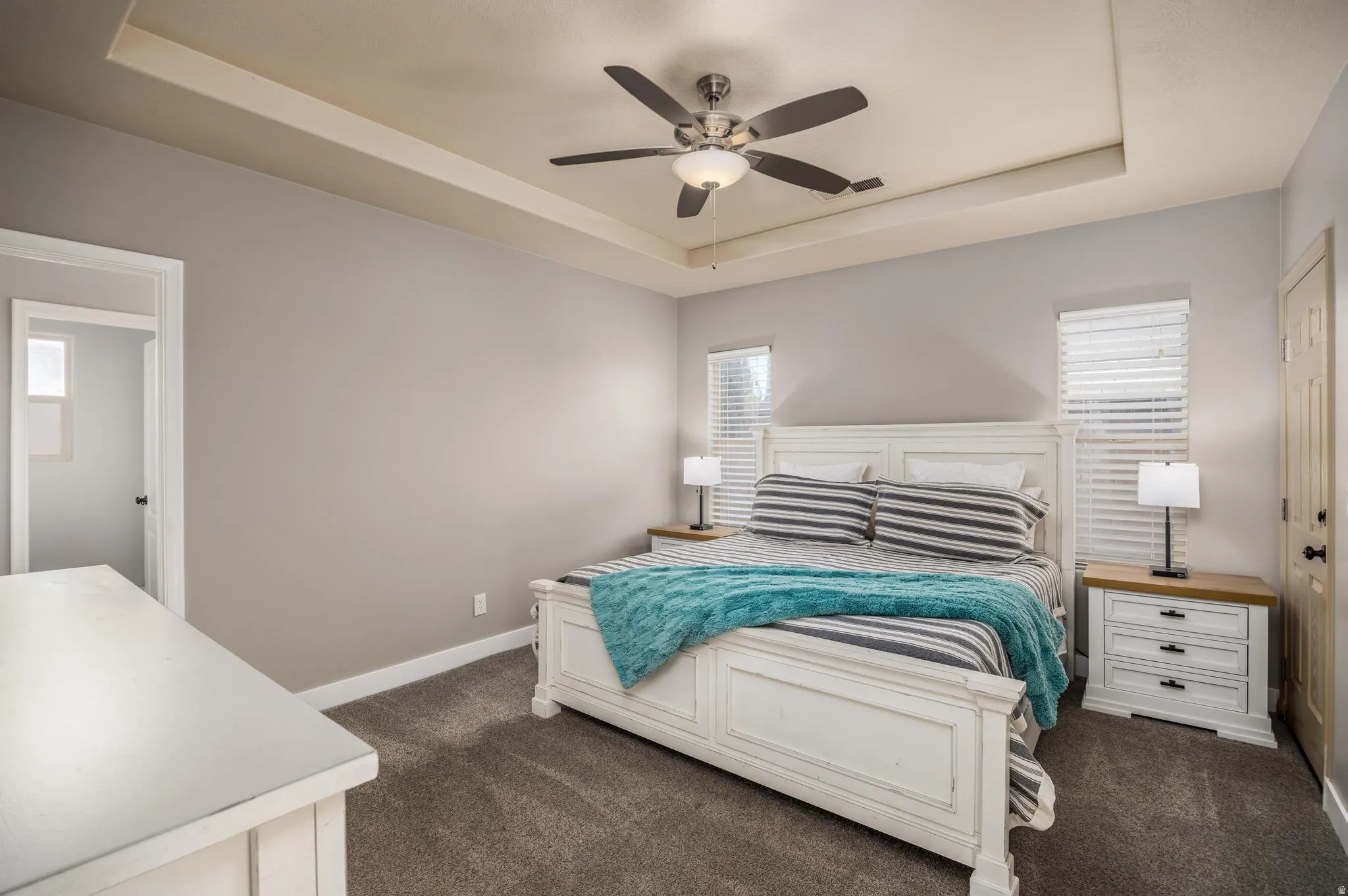 Bedroom featuring a tray ceiling and dark colored carpet