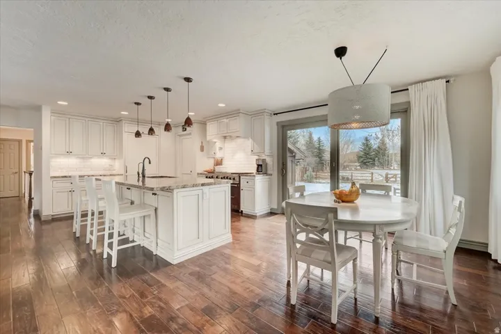 Dining area with dark wood-style floors, a textured ceiling, and recessed lighting
