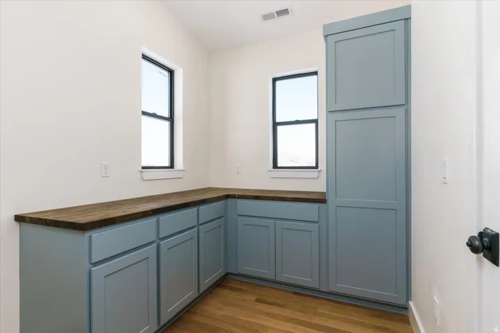 Kitchen featuring butcher block countertops, dark wood finished floors, and blue cabinets