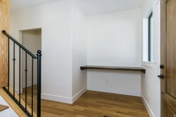 Stairway with wood finished floors and baseboards