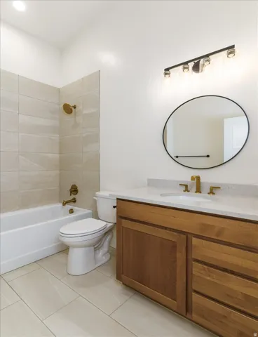 Bathroom with vanity, shower / bath combination, and light tile patterned floors