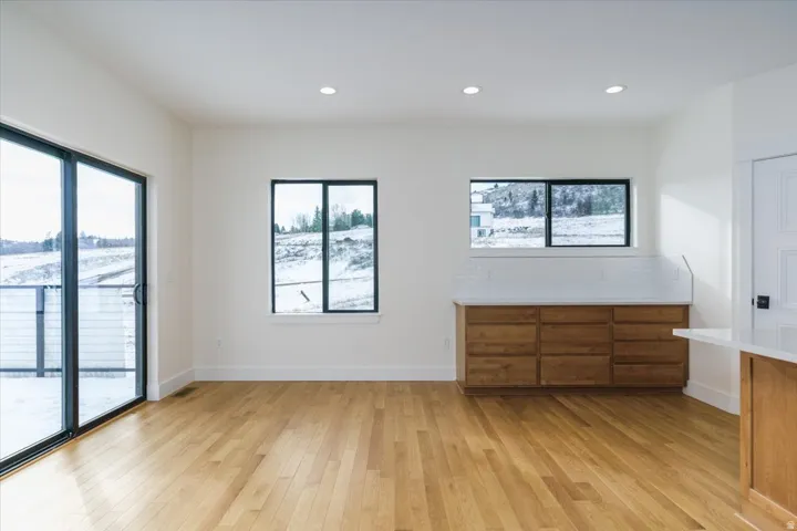 Unfurnished bedroom with multiple windows, light wood-style flooring, access to outside, and recessed lighting