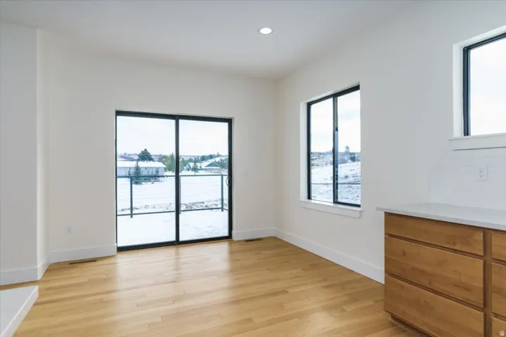 Empty room with light wood-style flooring, plenty of natural light, and recessed lighting