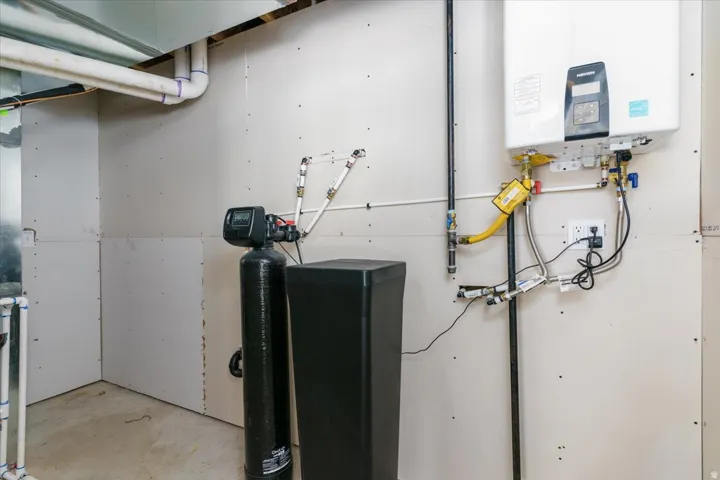 Utility room featuring tankless water heater