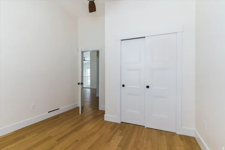 Unfurnished bedroom featuring a closet, light wood-type flooring, and a ceiling fan