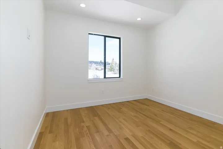 Spare room with light wood finished floors and recessed lighting