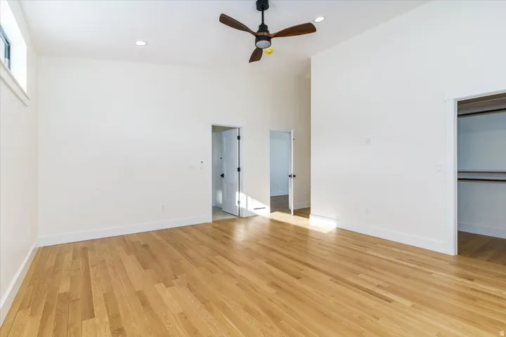 Unfurnished bedroom with light wood-style floors, a ceiling fan, high vaulted ceiling, and recessed lighting